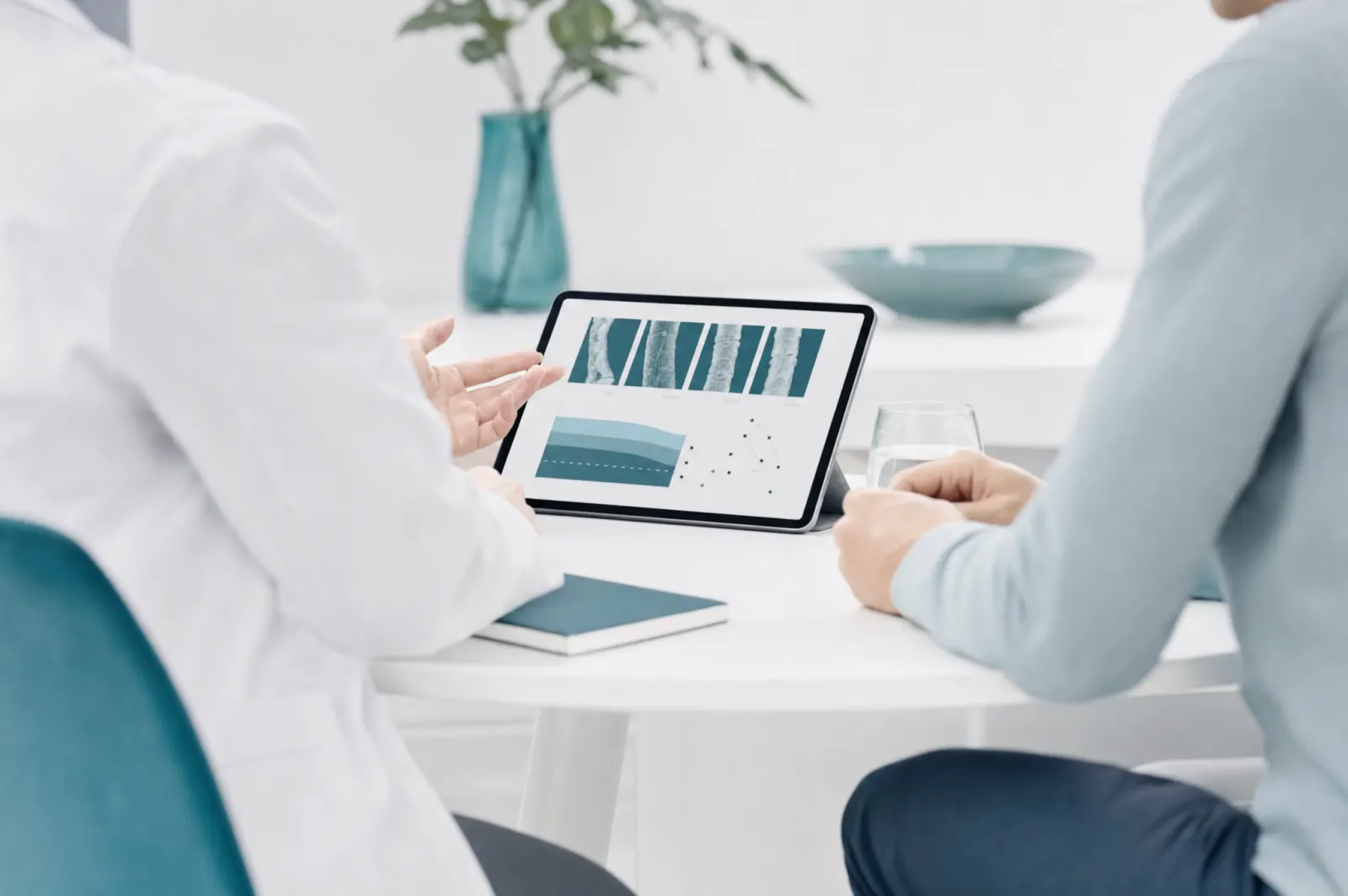Zwei Personen besprechen Diagramme auf einem Tablet
